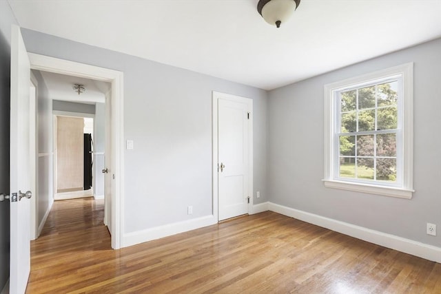 unfurnished bedroom featuring light hardwood / wood-style flooring and a closet