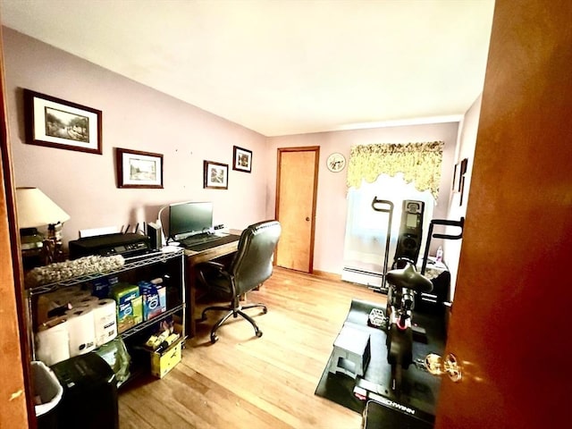 office space featuring a baseboard heating unit and wood-type flooring