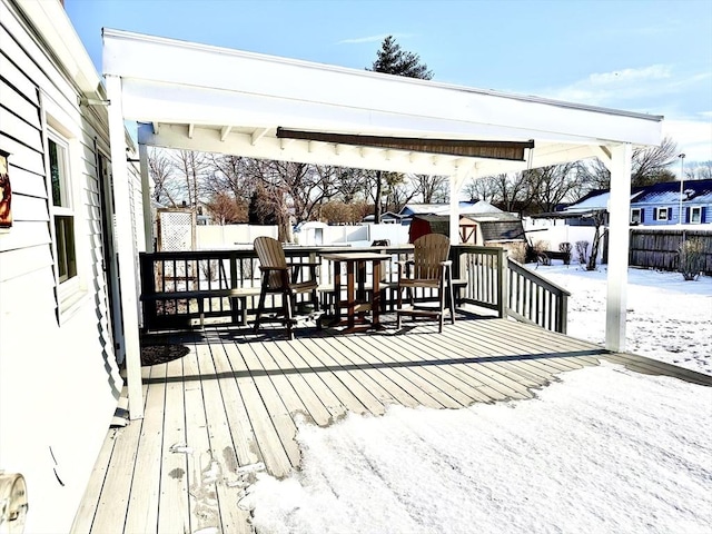 snow covered deck with a storage shed