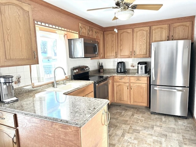 kitchen featuring sink, appliances with stainless steel finishes, backsplash, light stone counters, and kitchen peninsula