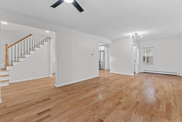 unfurnished living room featuring baseboard heating, ceiling fan, and light hardwood / wood-style floors