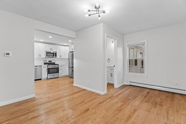 unfurnished living room featuring an inviting chandelier, light hardwood / wood-style flooring, and baseboard heating