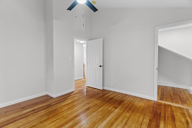 unfurnished room with hardwood / wood-style floors, high vaulted ceiling, and ceiling fan