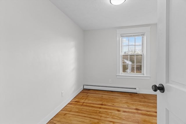 empty room with light hardwood / wood-style floors and a baseboard radiator