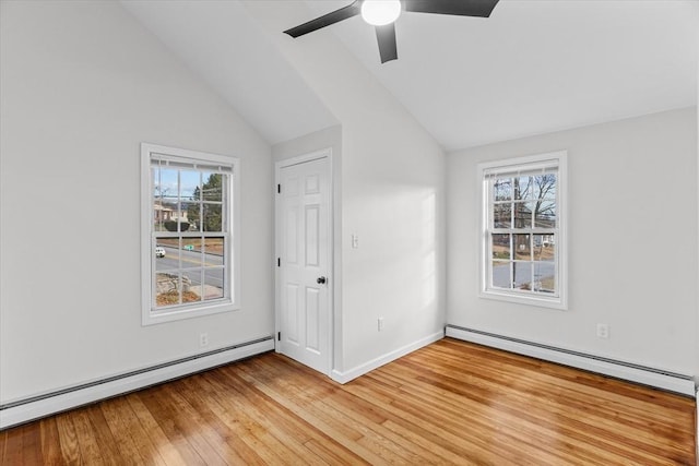 unfurnished room featuring baseboard heating, a wealth of natural light, and light hardwood / wood-style flooring