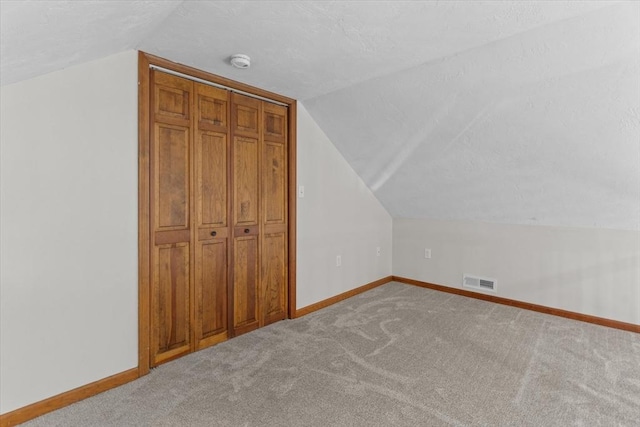 additional living space featuring carpet and vaulted ceiling