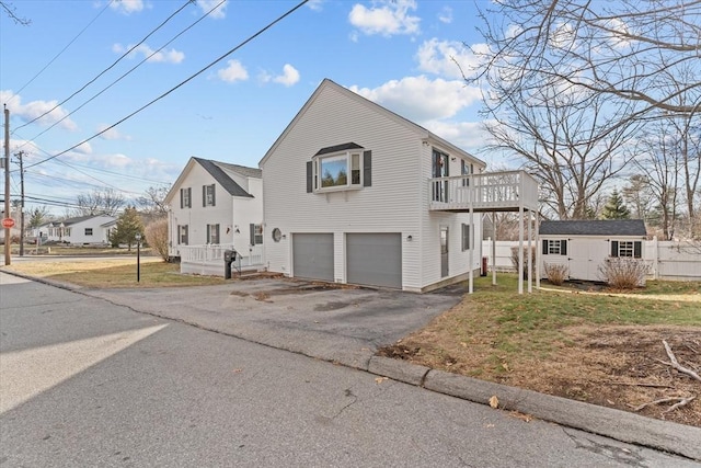 view of front of home featuring a garage, a wooden deck, and a storage shed