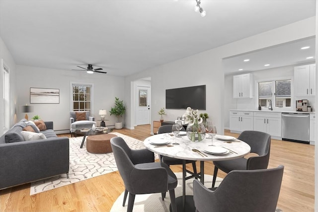 dining room featuring light hardwood / wood-style floors, ceiling fan, and sink