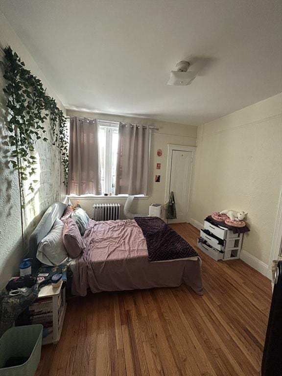 1691 Commonwealth Unit 32, Boston, MA 02135 - bedroom with radiator heating unit, wood finished floors, and baseboards