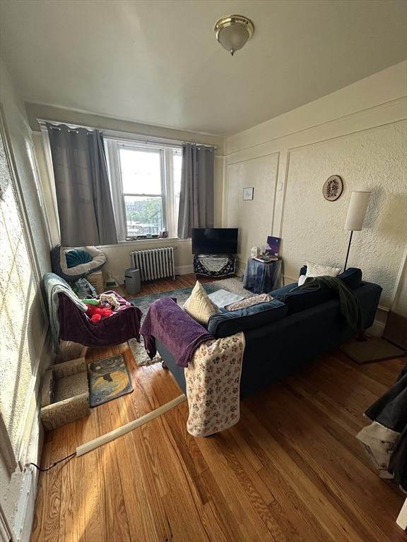 1691 Commonwealth Unit 32, Boston, MA 02135 - living area with radiator heating unit and wood finished floors