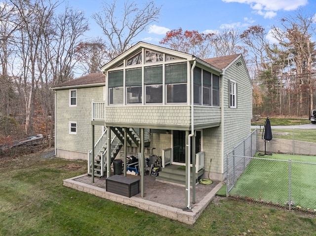 back of house featuring a sunroom, a yard, and a patio