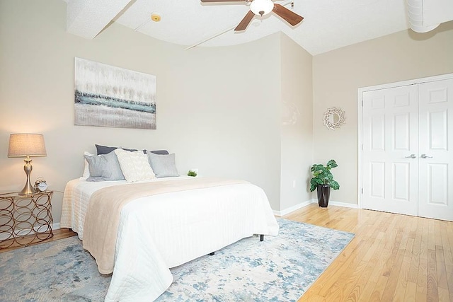 bedroom featuring a closet, a ceiling fan, baseboards, and wood finished floors