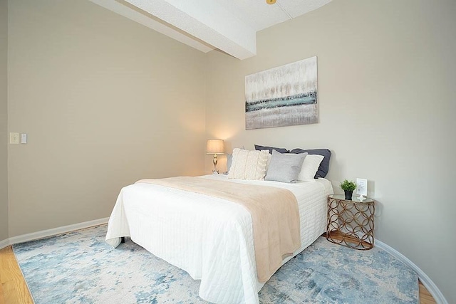 bedroom featuring beamed ceiling and baseboards