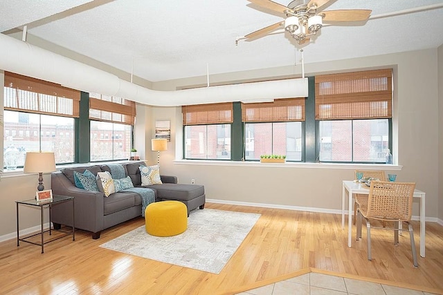 living room with wood finished floors, a healthy amount of sunlight, baseboards, and a textured ceiling