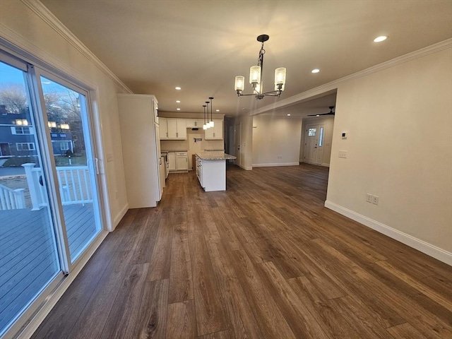 unfurnished living room with crown molding, dark wood-type flooring, and ceiling fan with notable chandelier