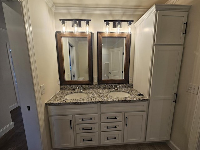 bathroom featuring vanity, hardwood / wood-style floors, and ornamental molding