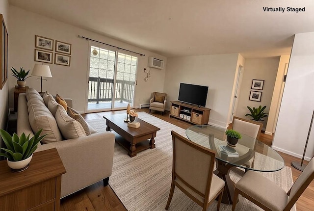 living room featuring an AC wall unit, baseboards, and wood finished floors