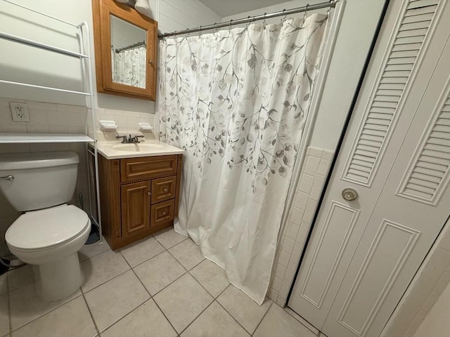 bathroom featuring tile patterned floors, a shower with curtain, toilet, tile walls, and vanity