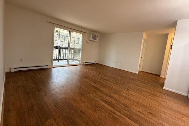 spare room with a baseboard radiator, baseboards, an AC wall unit, and wood finished floors