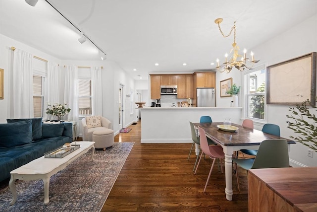 dining space featuring a chandelier, wood finished floors, track lighting, baseboards, and recessed lighting