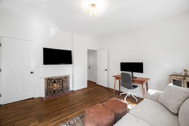 living room with a fireplace with flush hearth, wood finished floors, and baseboards