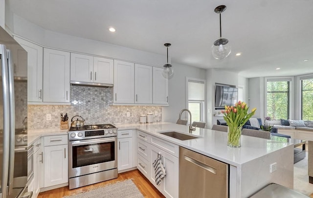 36 Hall Unit 1, Boston, MA 02130 - kitchen featuring appliances with stainless steel finishes, a sink, open floor plan, a peninsula, and white cabinetry