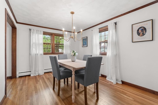 dining area with a chandelier, crown molding, plenty of natural light, light wood-style flooring, and a baseboard heating unit