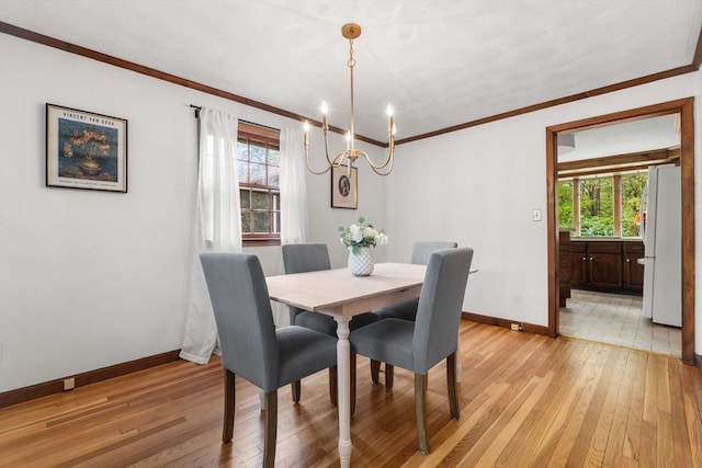 dining room featuring a chandelier, baseboards, healthy amount of natural light, light wood-type flooring, and ornamental molding