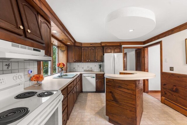 kitchen with white appliances, a sink, baseboard heating, under cabinet range hood, and light countertops