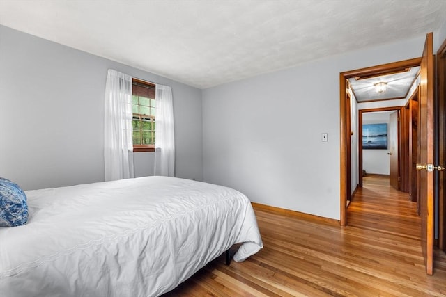 bedroom with wood finished floors and baseboards