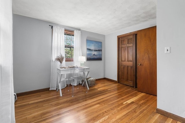 interior space featuring light wood-type flooring and baseboards