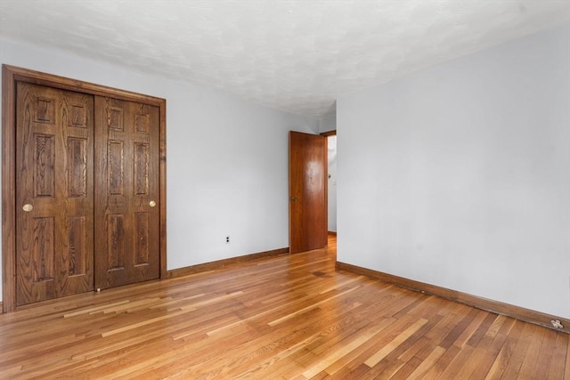 unfurnished bedroom featuring baseboards and light wood finished floors