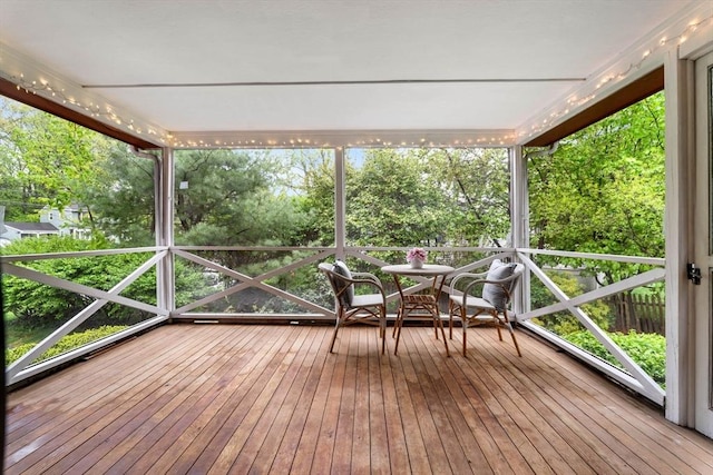 unfurnished sunroom with view of wooded area