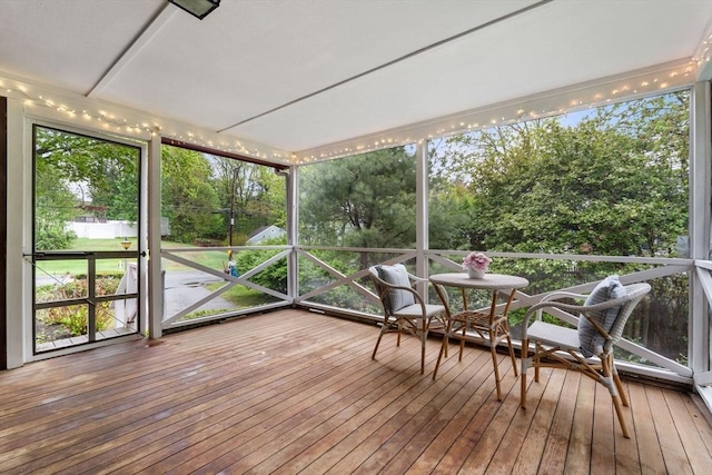 sunroom / solarium with view of scattered trees