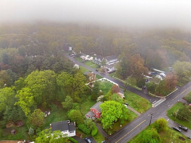 aerial view of property's location with a heavily wooded area and nearby suburban area