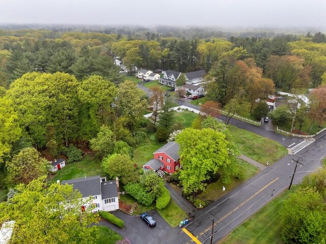 aerial overview of property's location with nearby suburban area and a heavily wooded area