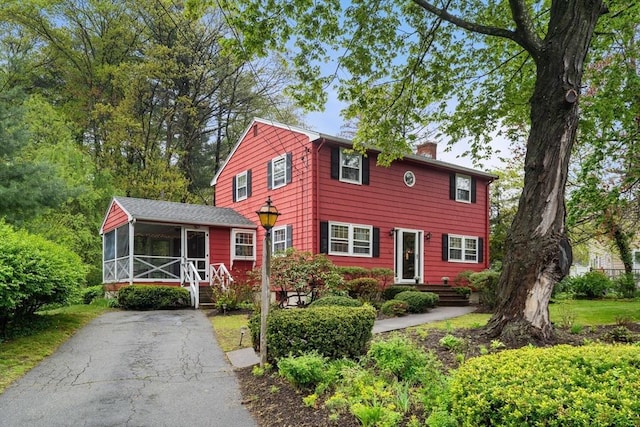 view of front of house featuring a sunroom and a chimney