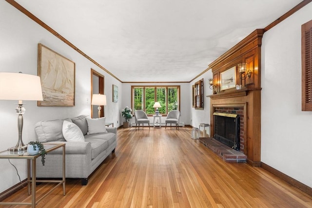 living room with ornamental molding, light wood-style flooring, a brick fireplace, and baseboards
