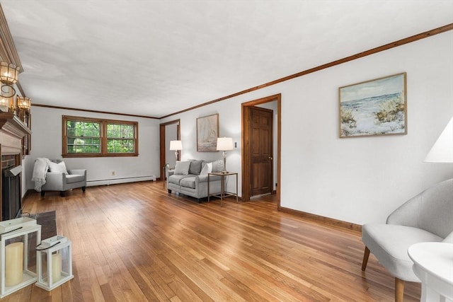 living area featuring a baseboard heating unit, light wood-style floors, a fireplace, ornamental molding, and baseboards