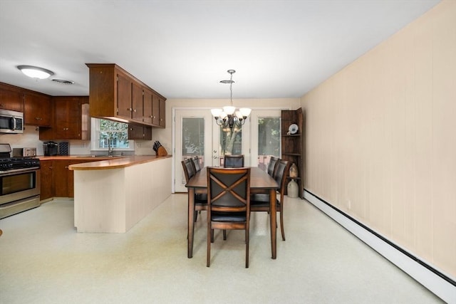 dining area featuring a baseboard heating unit, a notable chandelier, and visible vents