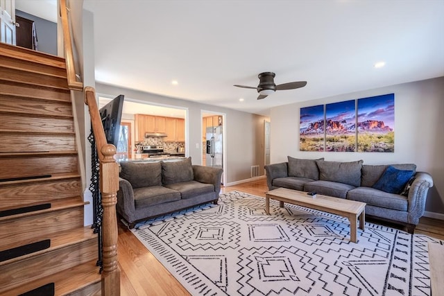 living room featuring recessed lighting, stairway, baseboards, and wood finished floors