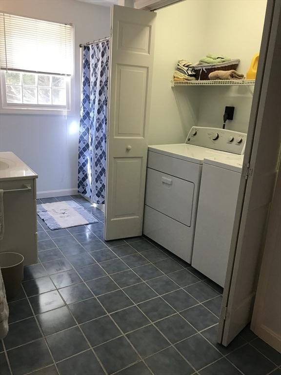 laundry area featuring laundry area, dark tile patterned floors, and separate washer and dryer