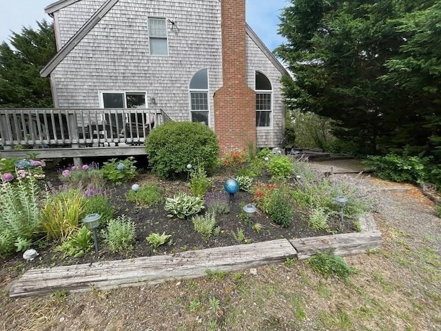 rear view of property featuring a deck and a chimney