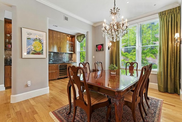 2 Cumston St Unit 2, Boston, MA 02118 - dining area featuring a bar, light wood-style flooring, a chandelier, baseboards, and ornamental molding