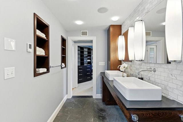 2 Cumston St Unit 2, Boston, MA 02118 - bathroom featuring baseboards, double vanity, marble look tile flooring, and backsplash