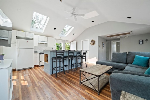 44 Macarthur Ln, Marshfield, MA 02050 - living room featuring a skylight, lofted ceiling, light wood-style floors, and ceiling fan
