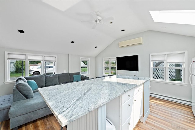 44 Macarthur Ln, Marshfield, MA 02050 - kitchen featuring a baseboard heating unit, a wall mounted AC, open floor plan, a skylight, and light wood-style flooring