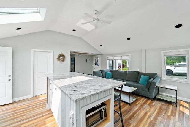 44 Macarthur Ln, Marshfield, MA 02050 - kitchen with vaulted ceiling, a center island, light wood-style floors, ceiling fan, and a skylight