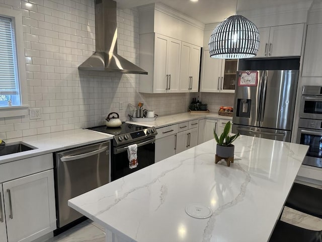 kitchen with white cabinets, light stone countertops, wall chimney range hood, and stainless steel appliances