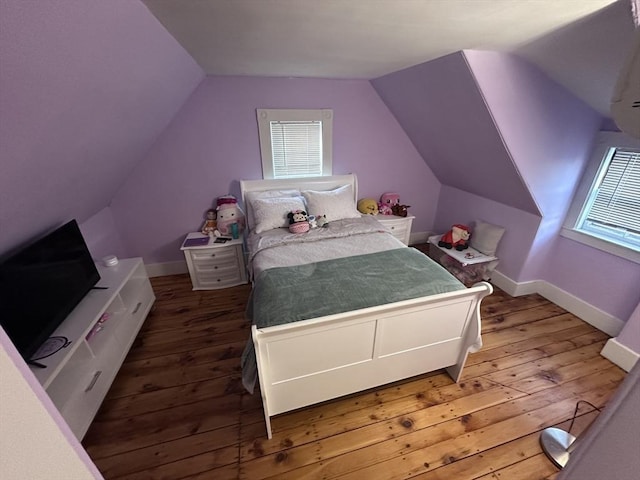 bedroom with hardwood / wood-style flooring, multiple windows, and lofted ceiling